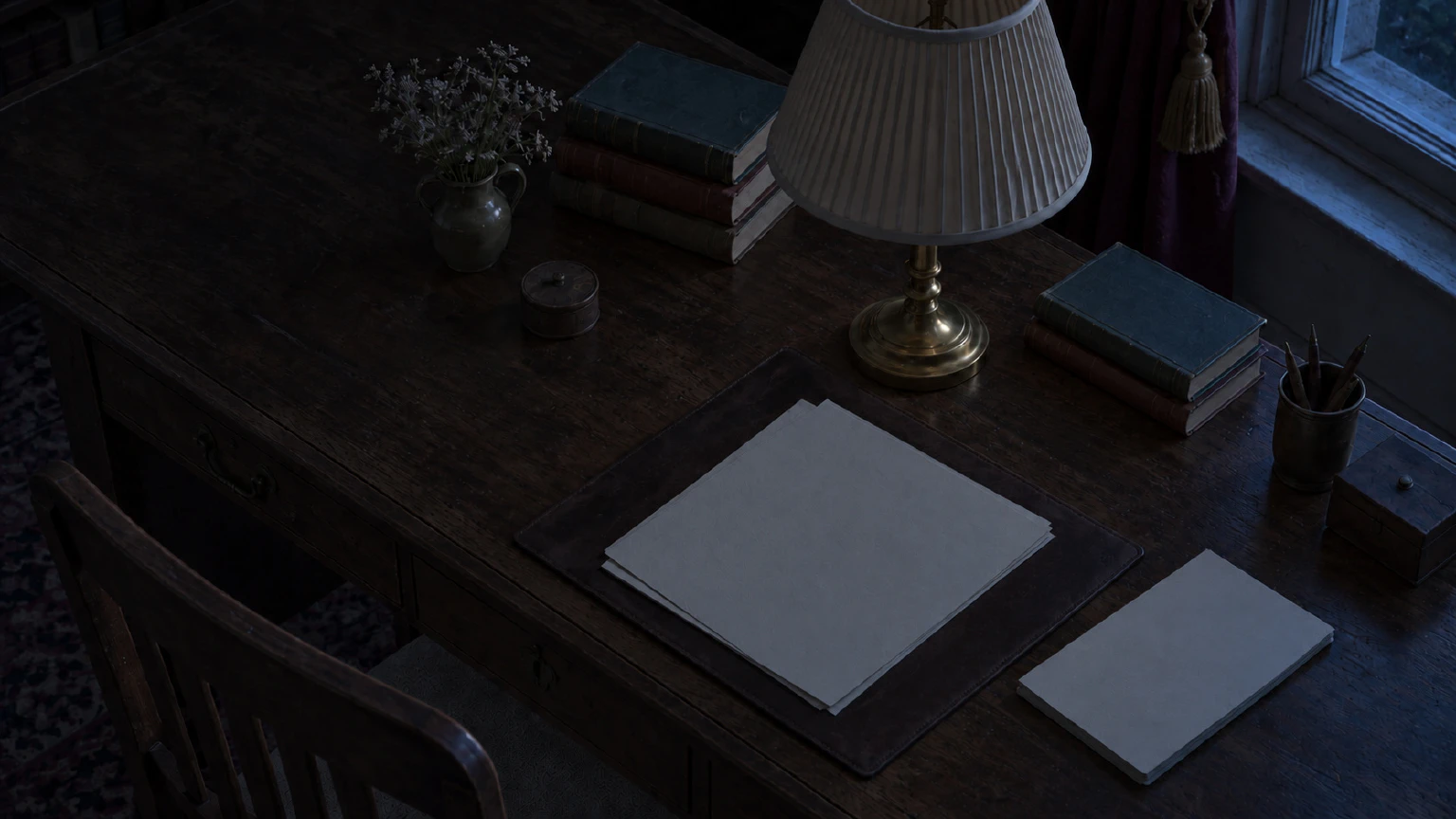 A mesa vista de cima, com a luminária apagada e a luz tênue da lua sobre o papel.